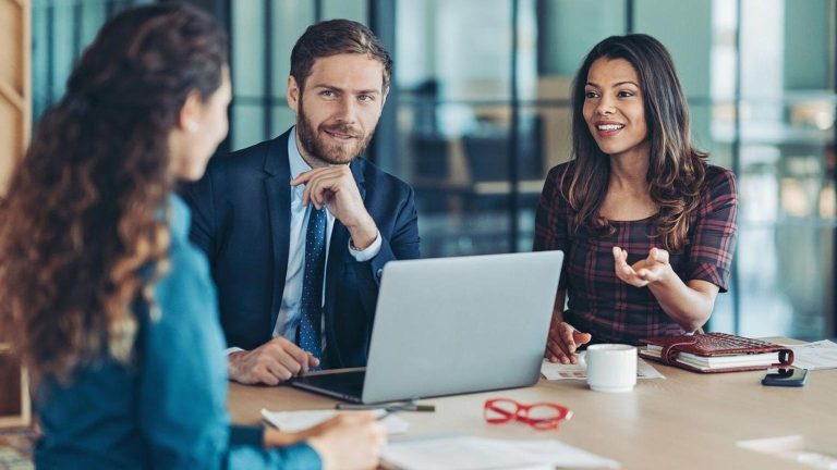 Business meeting with professionals discussing recruitment solutions strategy at office table with laptop