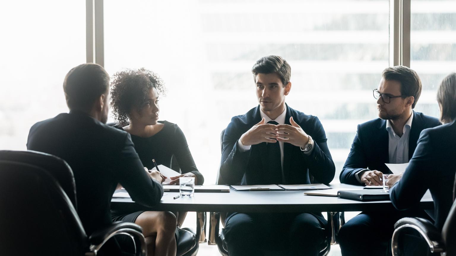 Executive search firm meeting with diverse business leaders discussing post-pandemic workforce strategies in a modern office.