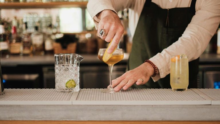 Bartender preparing a cocktail in a bar Alicante with a warm and inviting nightlife atmosphere