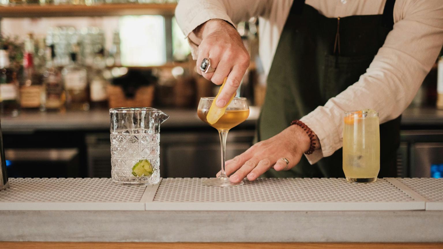Bartender preparing a cocktail in a bar Alicante with a warm and inviting nightlife atmosphere